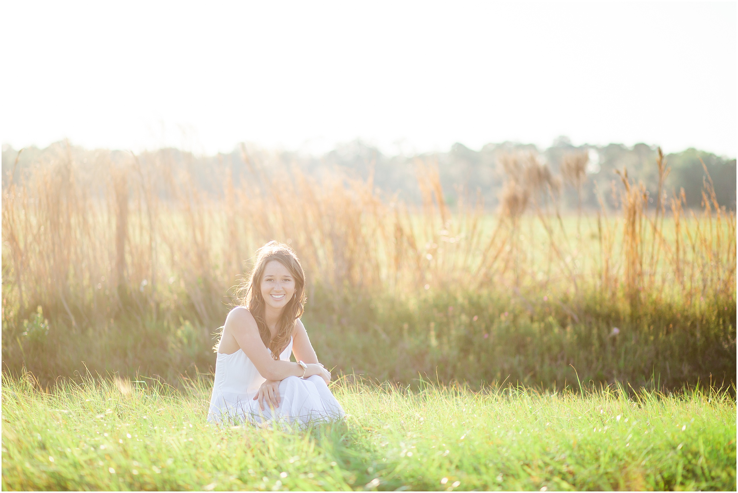 2019 Hardee High School Senior, Claire, poses in a golden grassy field in Wauchula FL at sunset.